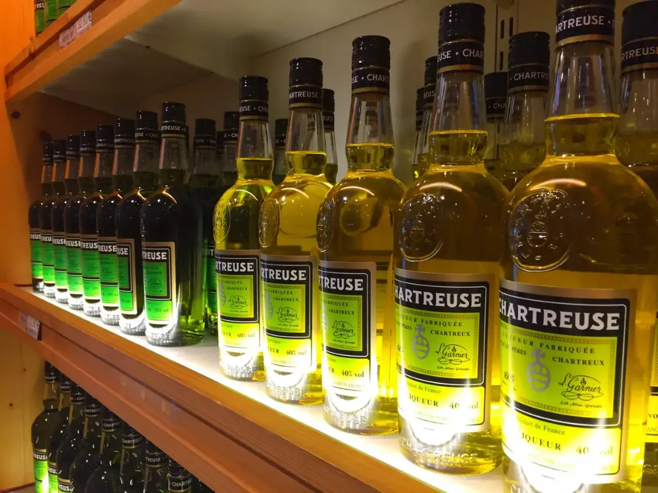 Butelki Chartreuse, zielonego i żółtego likieru, z etykietami sugerującymi, jak zrobić domowy likier typu chartreuse z 130 ziół.