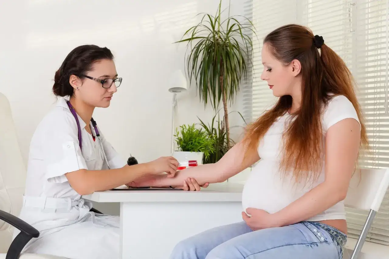 Lekarz diabetolog pobiera krew od ciężarnej pacjentki, dbając o jej zdrowie.