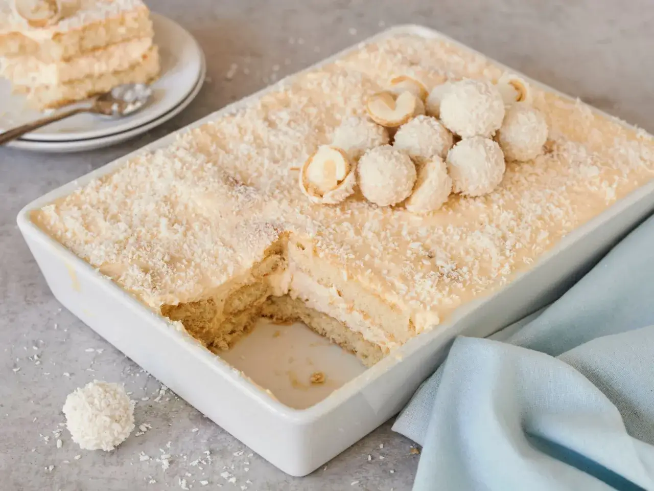 Raffaello Tiramisu: Ein cremiges Dessert mit Kokosraspeln und weißen Kugeln, das an Raffaello-Pralinen erinnert.