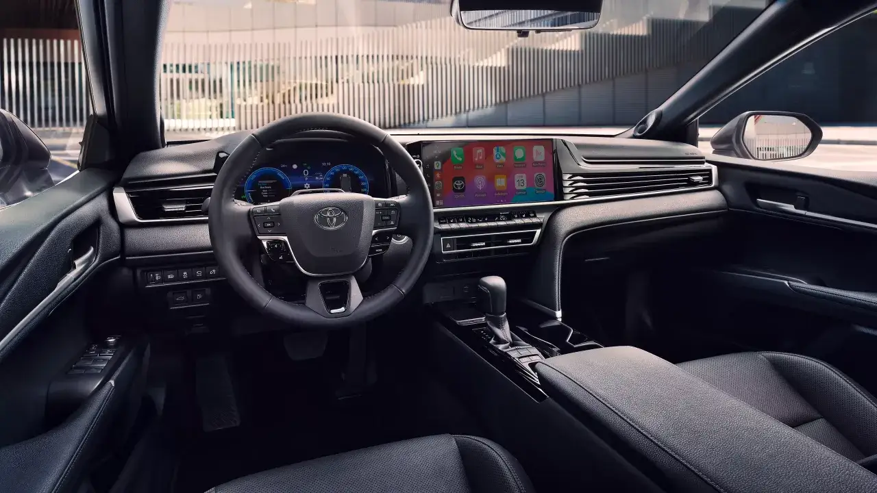 Wnętrze Toyoty Camry 2.5 Hybrid z nowoczesnym ekranem multimedialnym i cyfrowymi zegarami.