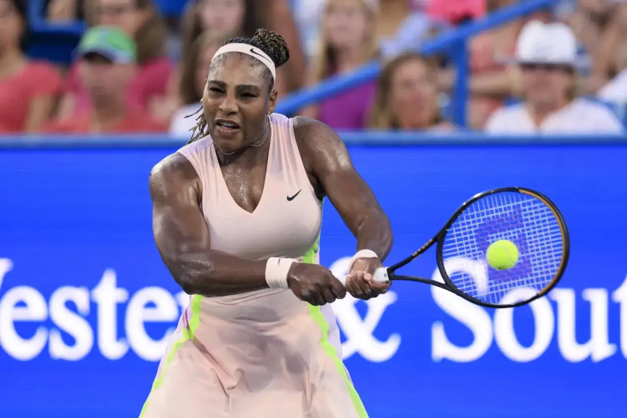 Tenista Serena Williams golpea la pelota con fuerza en un partido, concentrada y sudorosa.