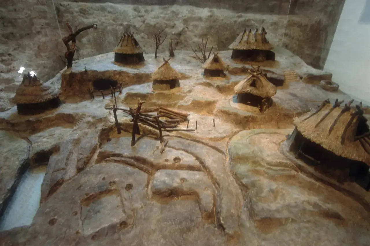 Modell einer Siedlung aus der Zeit um 753 rom. Strohgedeckte Hütten und ein Brunnen auf einem Hügel.