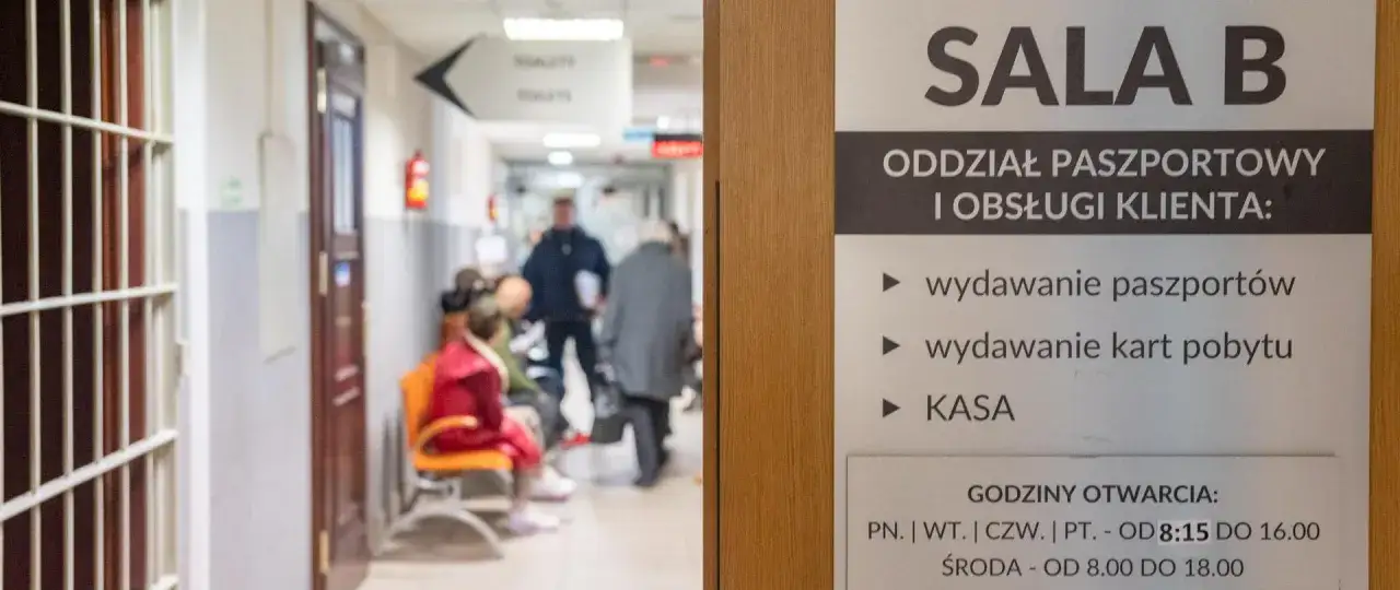 W poczekalni biura paszportowego Włocławek ludzie czekają na wydanie paszportów i kart pobytu.