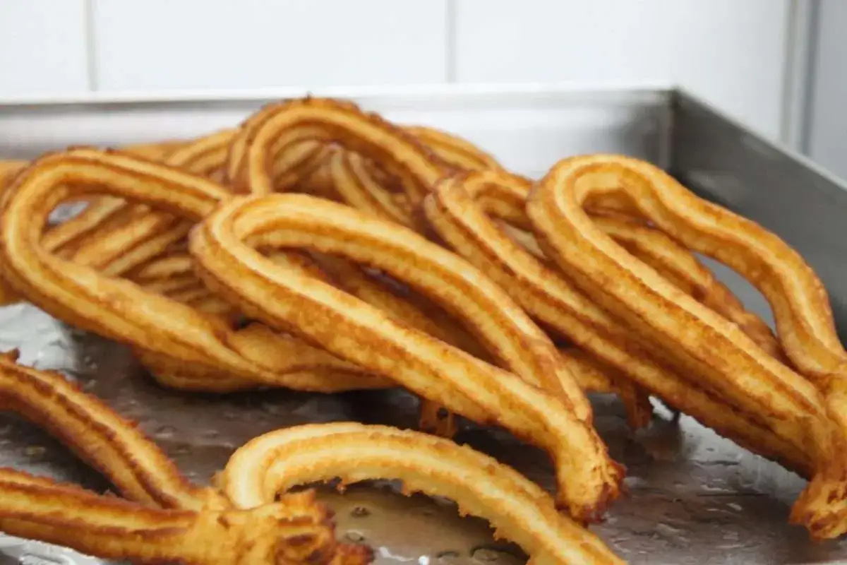 Un mucchio di churros dorati e croccanti, pronti per essere gustati. Una deliziosa churros ricetta da provare subito!