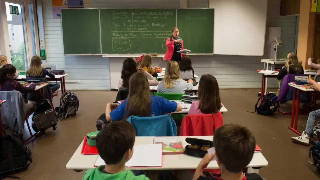 Lehrerin erklärt Englisch im Klassenzimmer. Hier lernen Schülerinnen und Schüler, die zu den besten Schulen Deutschlands gehören könnten.