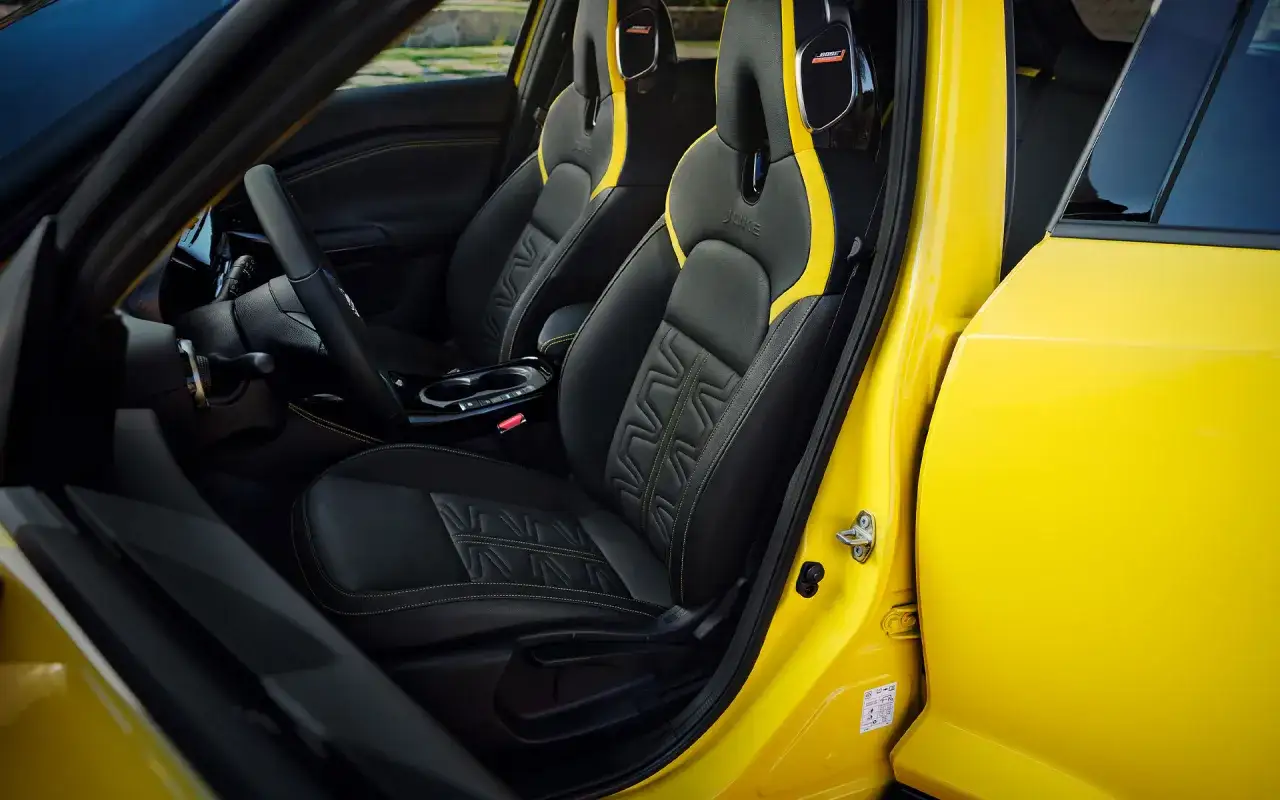 Wnętrze ż&oacute;łtego Nissan Juke Sport z czarnymi fotelami i ż&oacute;łtymi akcentami.