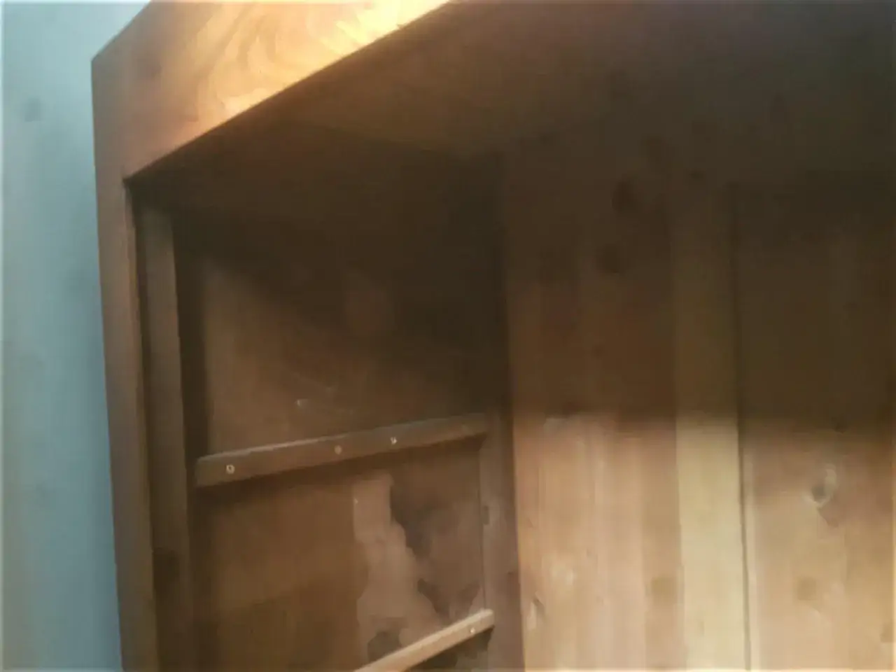 Int&eacute;rieur d'une armoire ancienne en bois, pr&ecirc;te &agrave; d&eacute;monter. Les &eacute;tag&egrave;res sont visibles, ainsi que les marques du temps.