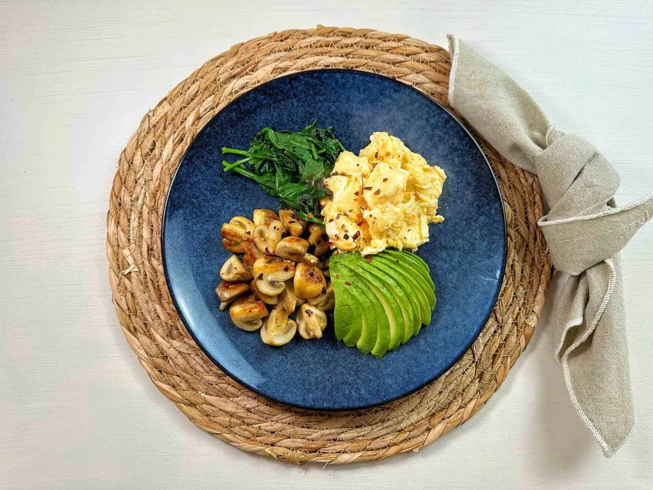 Pyszne keto śniadanie: jajecznica, pieczarki, szpinak i awokado. Idealny start dnia!