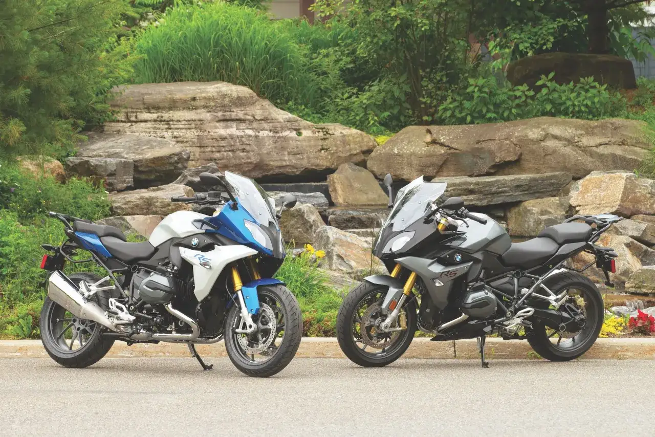 Dwa motocykle BMW R1200RS w różnych kolorach, stojące obok siebie. Wady tego modelu są dyskusyjne, ale wyglądają imponująco.