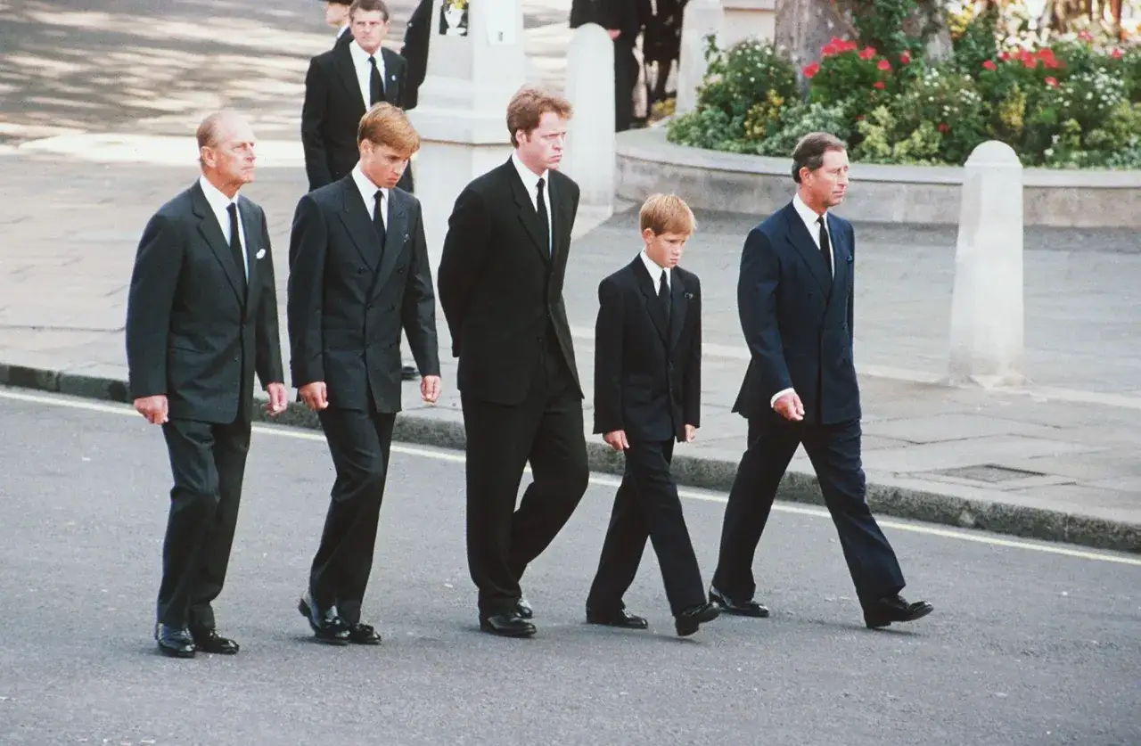Książę Filip, książę William, książę Harry i książę Karol w granatowych garniturach na pogrzebie.