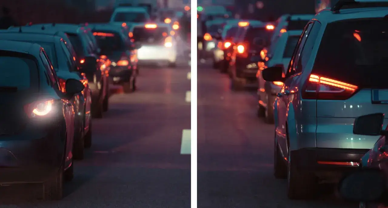 Coda di auto ferme nel traffico serale, con luci rosse accese. L'abbigliamento del traffico, con le sue luci, ha un significato di attesa e lentezza.