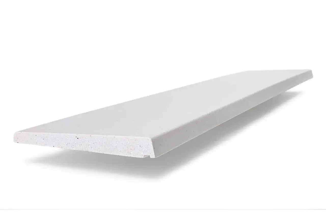 Un perfil de piedra blanco con motas, que es un vierteaguas, se proyecta sobre un fondo blanco.