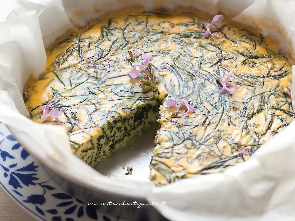 Una deliziosa frittata di agretti, guarnita con fiori viola, appena sfornata e pronta per essere gustata.