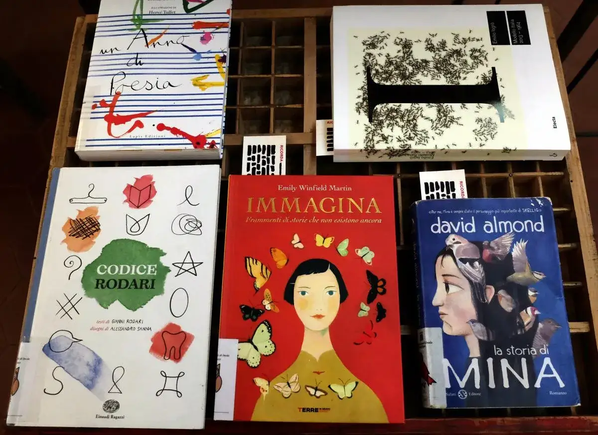 Libri disposti in una cassetta di legno, tra cui 