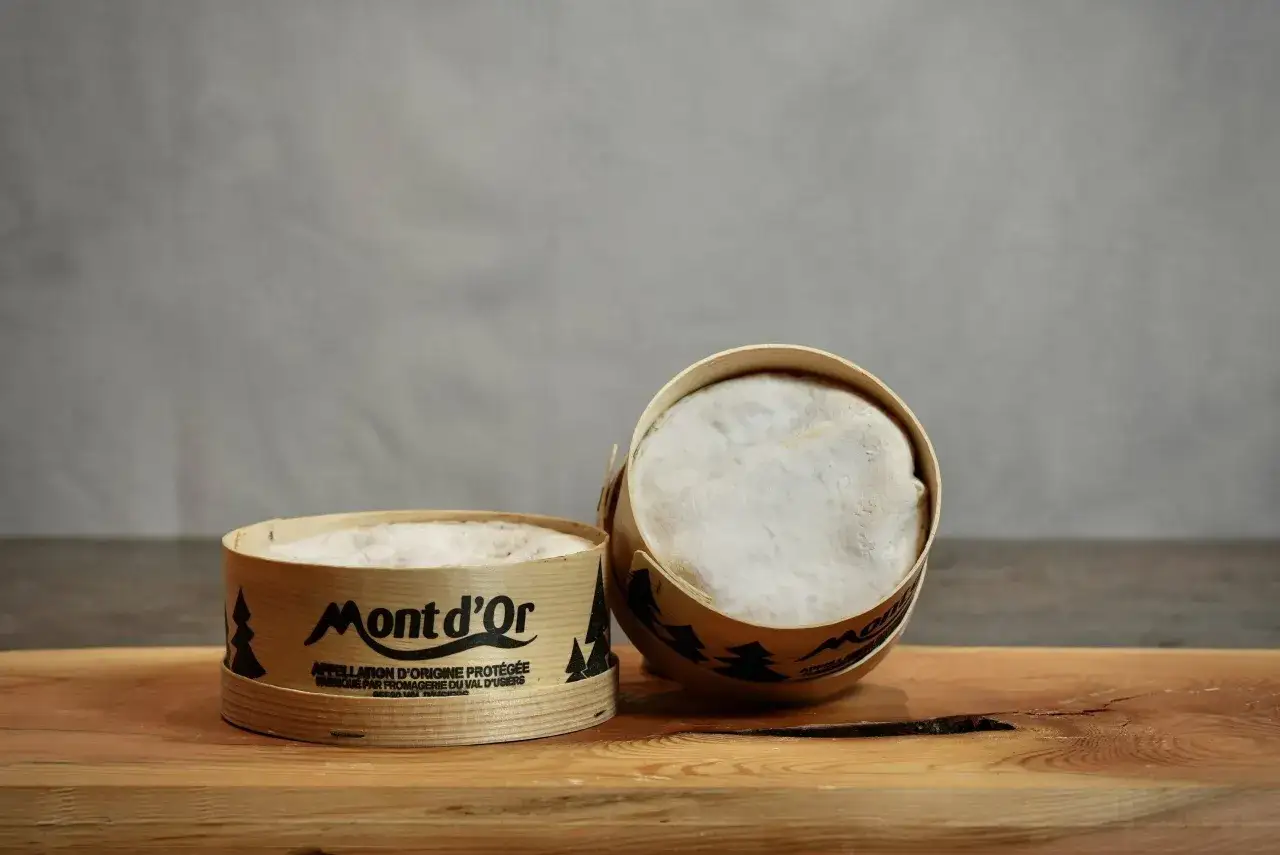 Deux boîtes de Mont d'Or, l'une ouverte, révèlent leur pâte crémeuse. Un délice à partager.