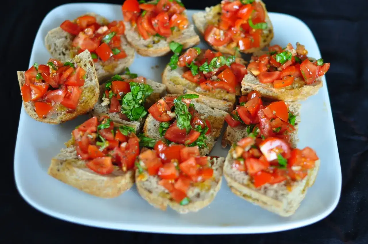 Mnóstwo chrupiących kromek z grzankami, obficie posypanych świeżymi, soczystymi pomidorami i bazylią. Idealna bruschetta z pomidorami na każdą okazję.