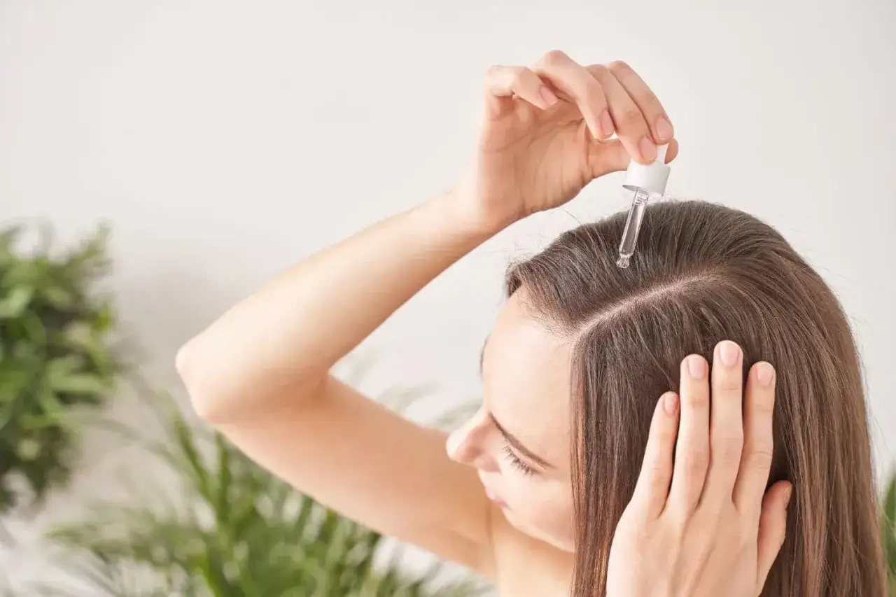 Application d'un sérum sur le cuir chevelu. Le résultat : des cheveux plus forts et brillants, un vrai avant après eau de rose cheveux.