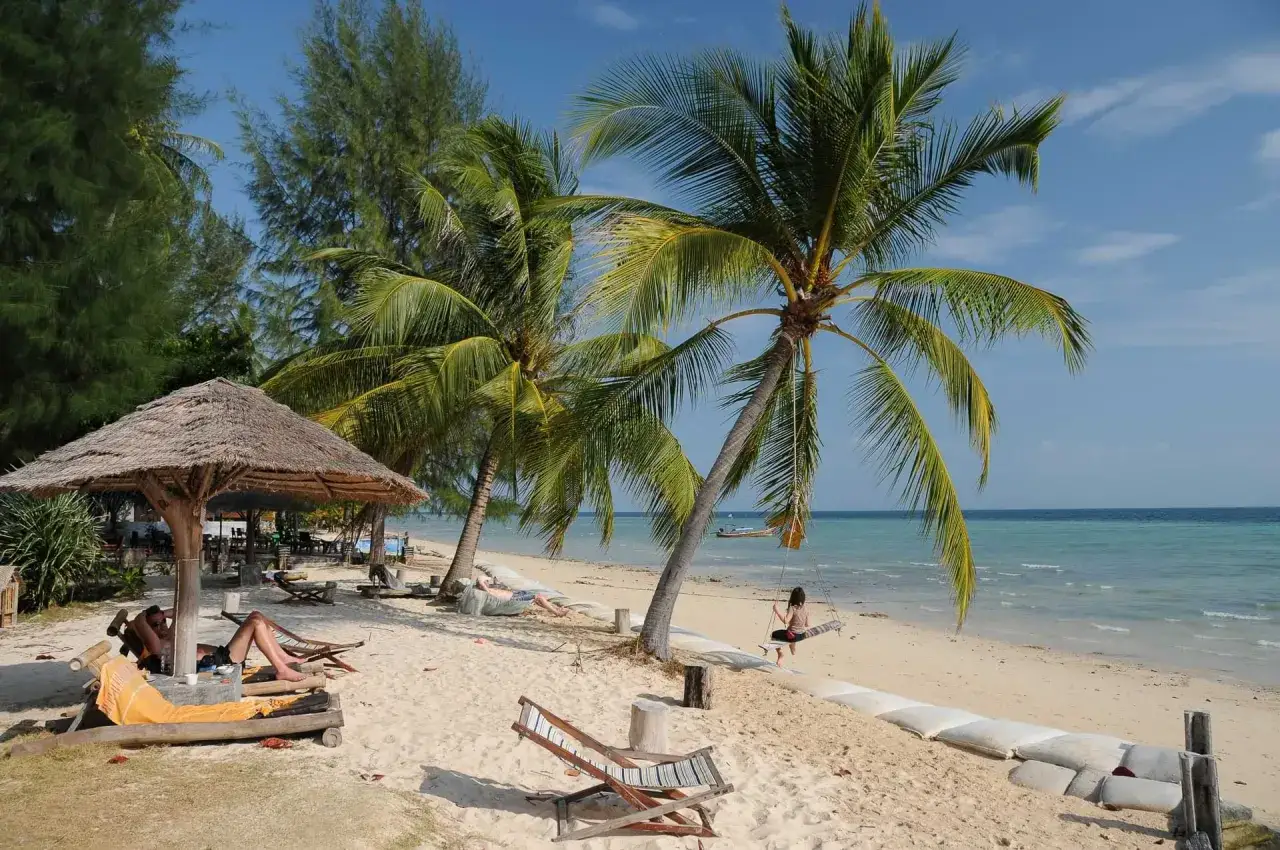 Entspannter Strandtag in Thailand: Palmen, Liegestühle und eine Schaukel am Meer. Ein Muss für jeden Urlaub!