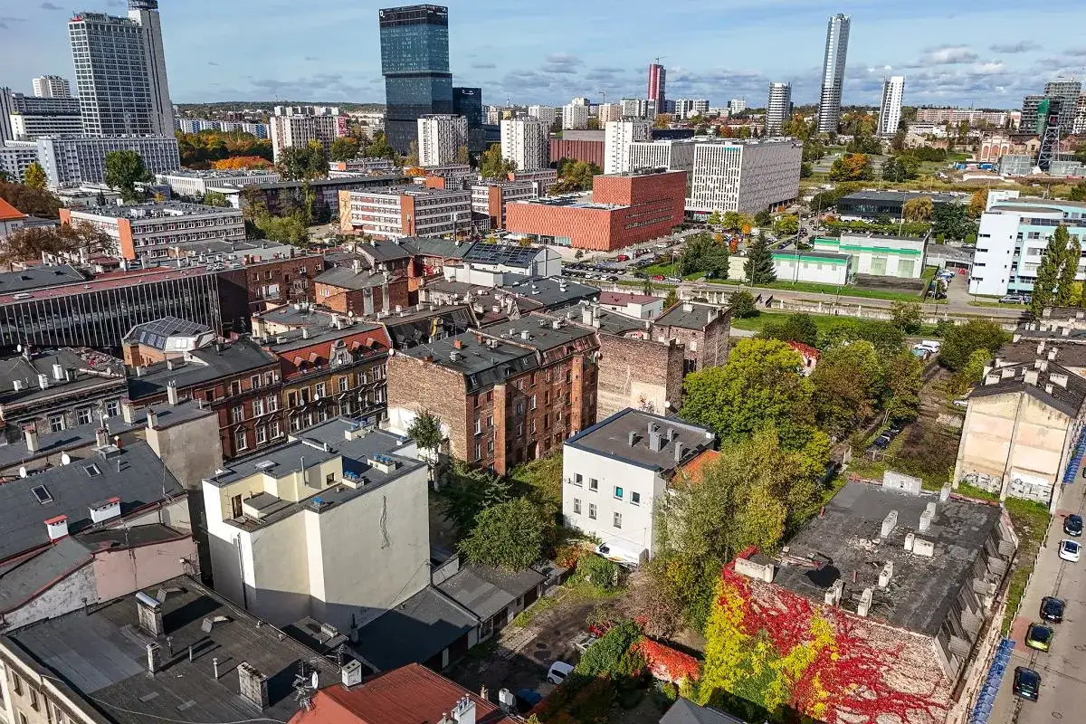 Widok na Katowice z lotu ptaka, gdzie nowoczesne budynki przeplatają się ze starszą architekturą. Widać tu wiele uczelni, które tworzą dynamiczny krajobraz miasta.