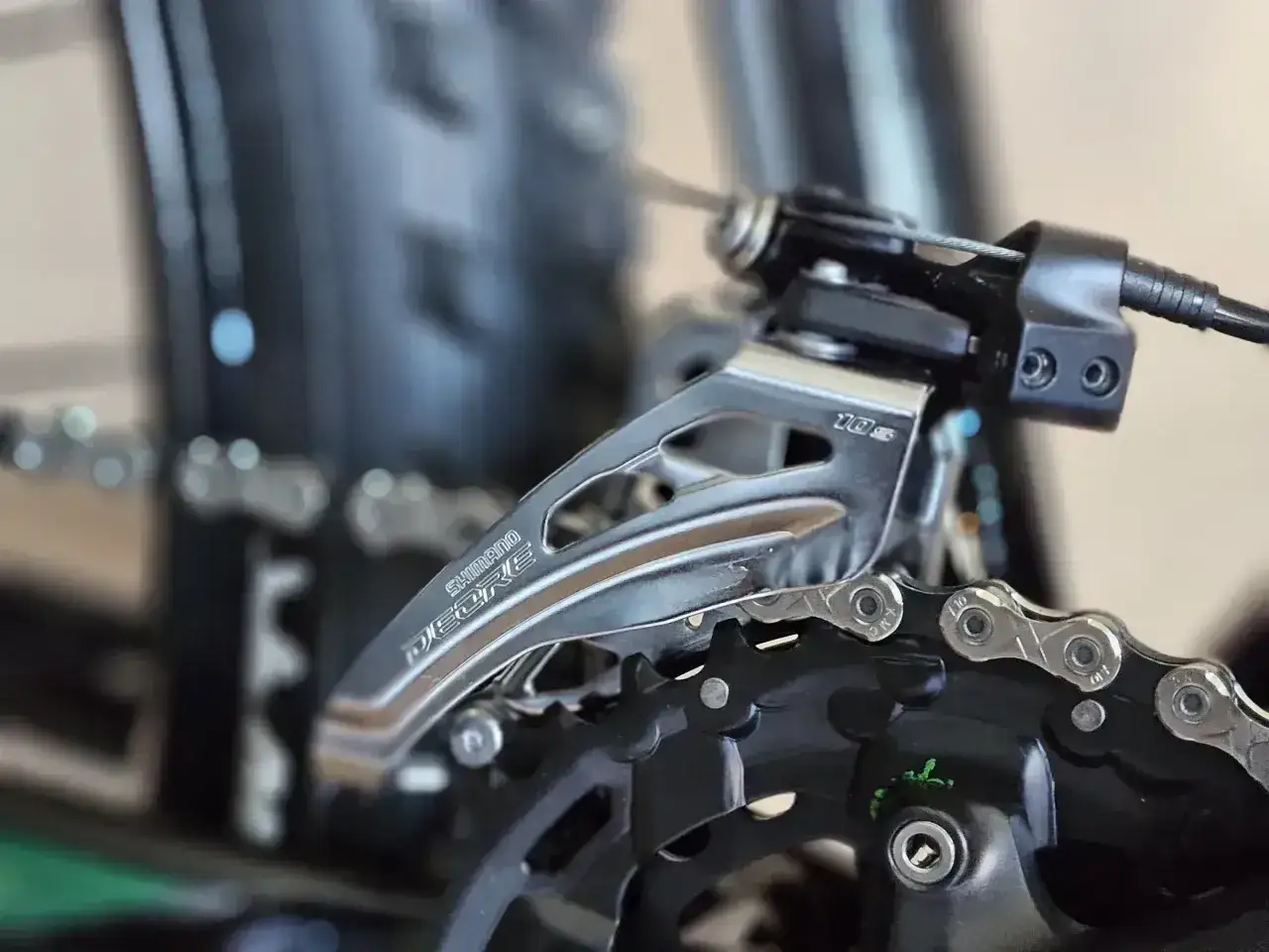 Zbliżenie na przednią przerzutkę Shimano Deore. Dowiedz się, jak zmieniać przerzutki w rowerze, by jazda była płynniejsza.