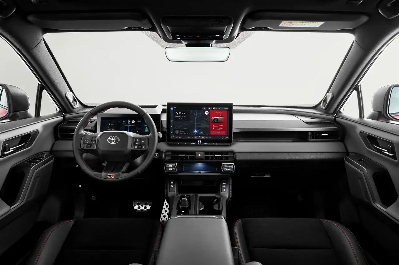 Wnętrze nowoczesnego SUV-a, przypominającego połączenie Lexusa i Toyoty, z dużym ekranem multimedialnym i sportową kierownicą GR.