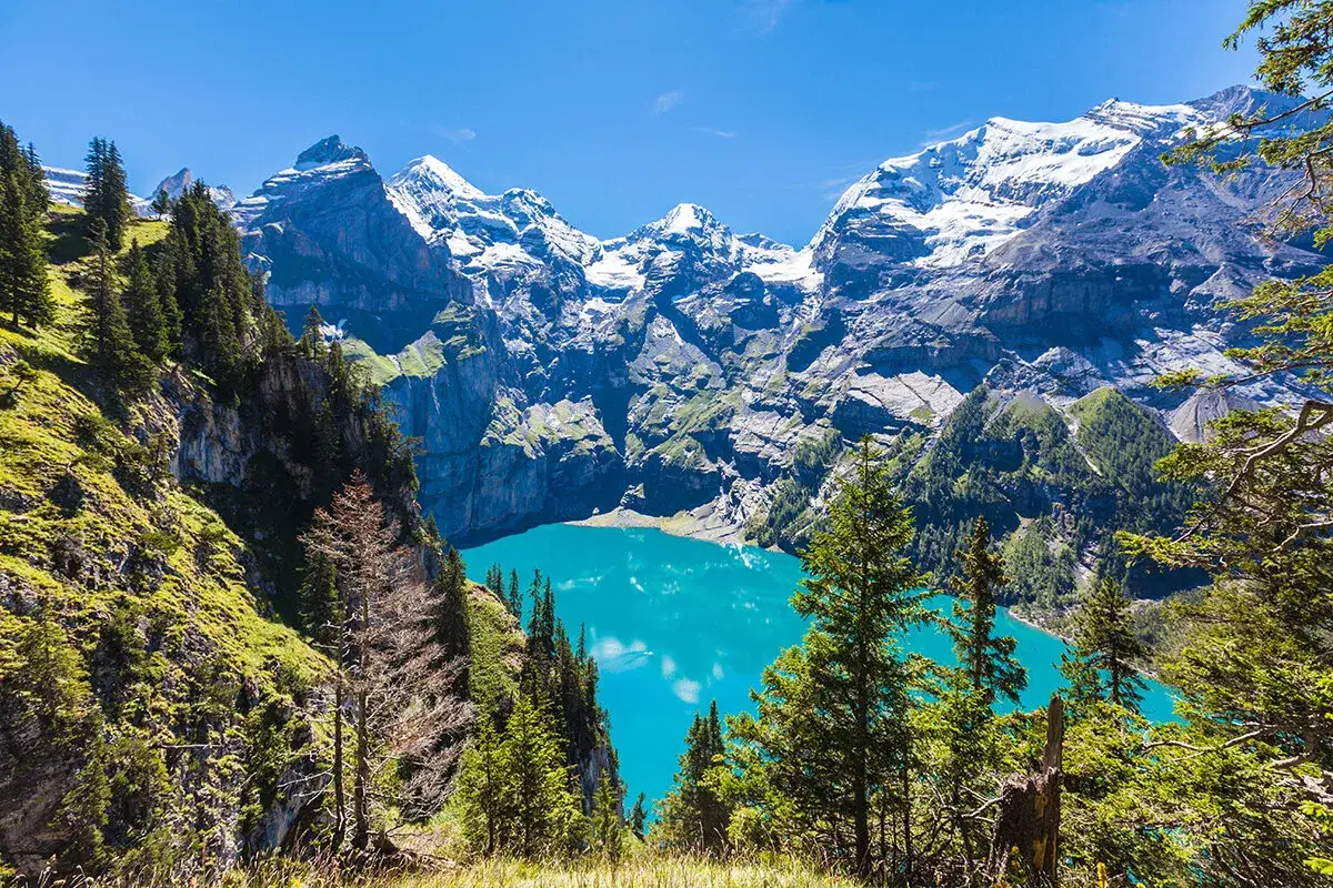 Vandra i Schweiz bland snöklädda berg och en turkosblå sjö. En dröm för alla som älskar natur och vandring.