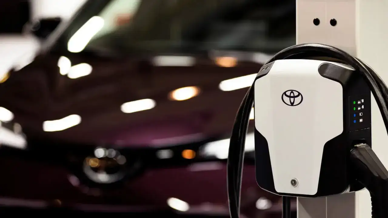 Ładowarka Toyota z kontrolkami stanu baterii. Sprawdź objawy zużytej baterii w używanym aucie hybrydowym przed zakupem.