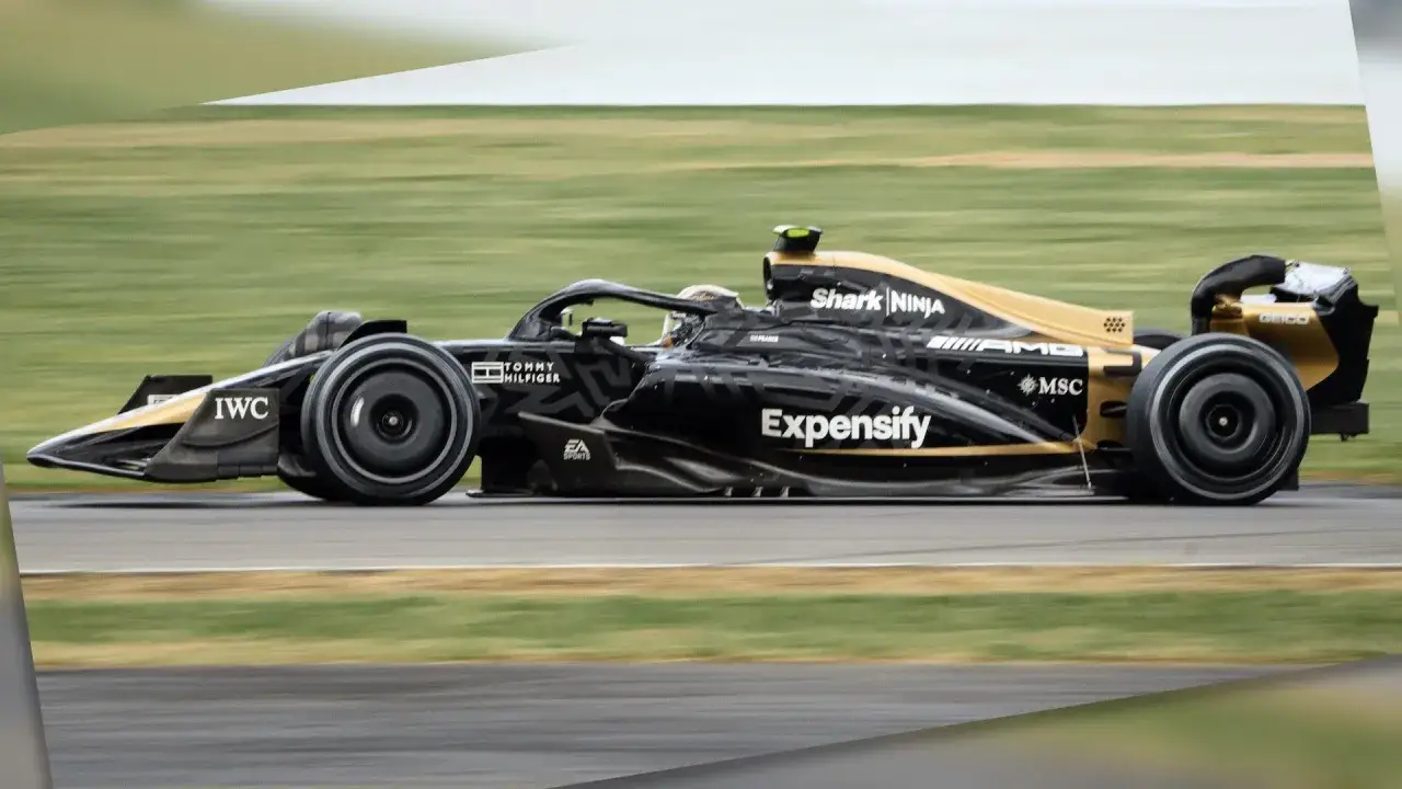 Coche de F1 negro y dorado en pista, como en una f1 pelicula.