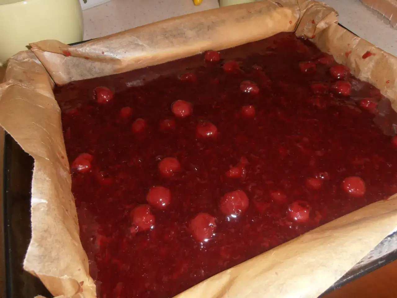 Pyszne ciasto bajka z wiśniami w trakcie pieczenia. Soczyste owoce zatopione w masie ciasta.