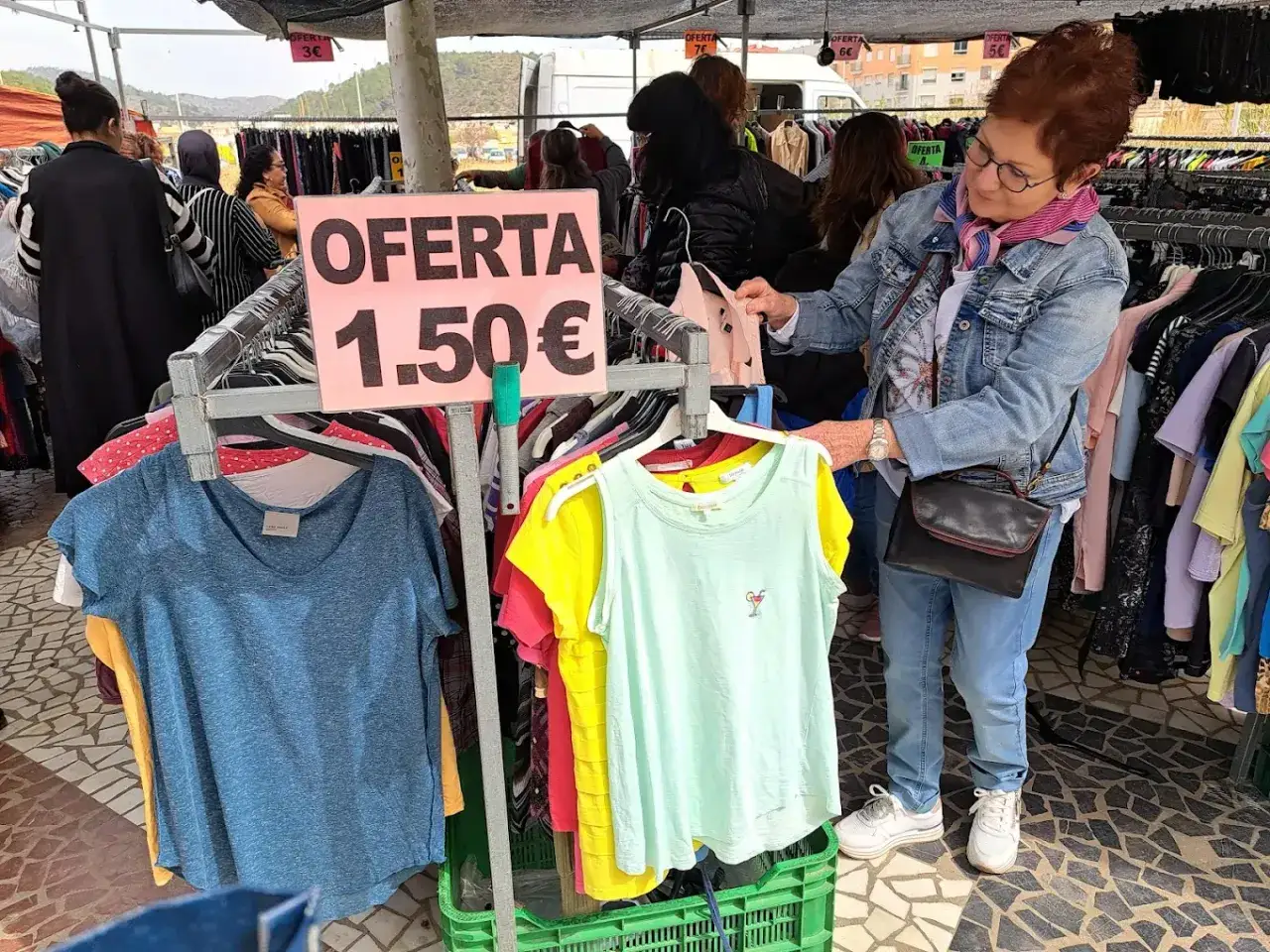 En el mercadillo de Gandía, una mujer busca ofertas de ropa a 1,50€.