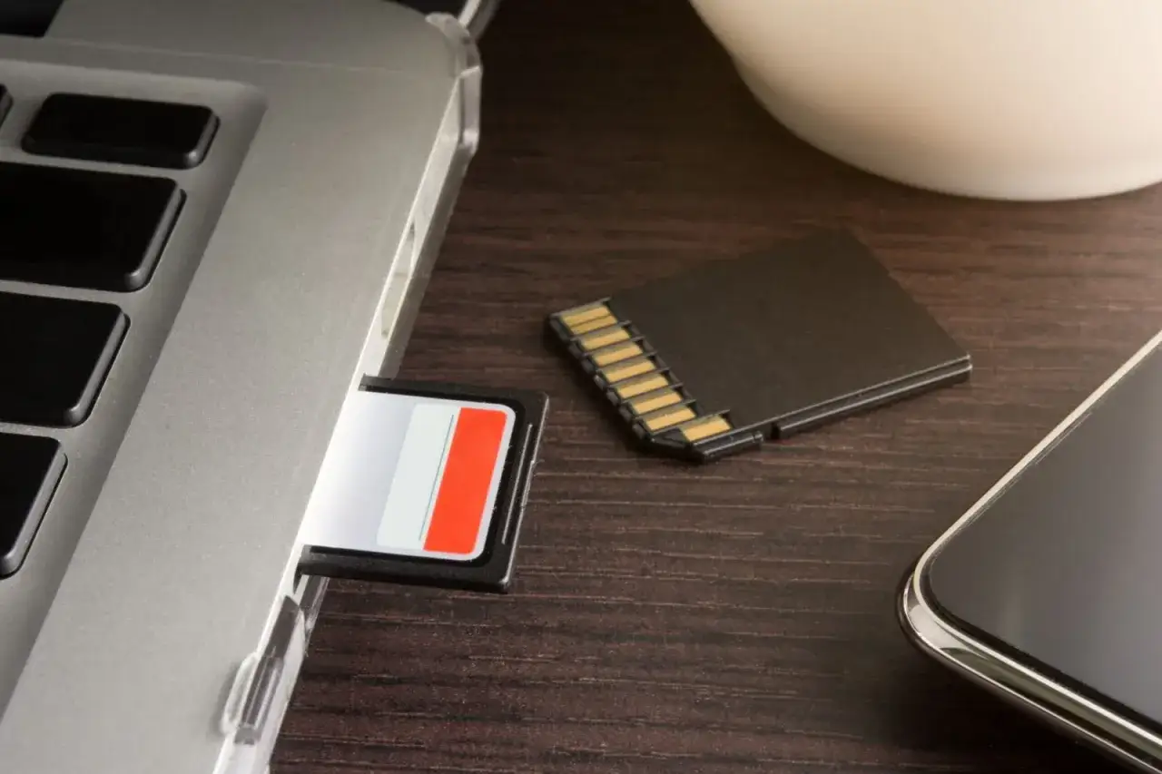 SD-Karte wird nicht mehr erkannt Samsung? Ein Laptop mit einer SD-Karte im Slot, daneben eine weitere SD-Karte und ein Smartphone.