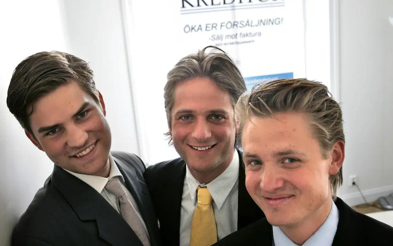 Tre unga män, potentiella grundare av Klarna, ler mot kameran i kostym.