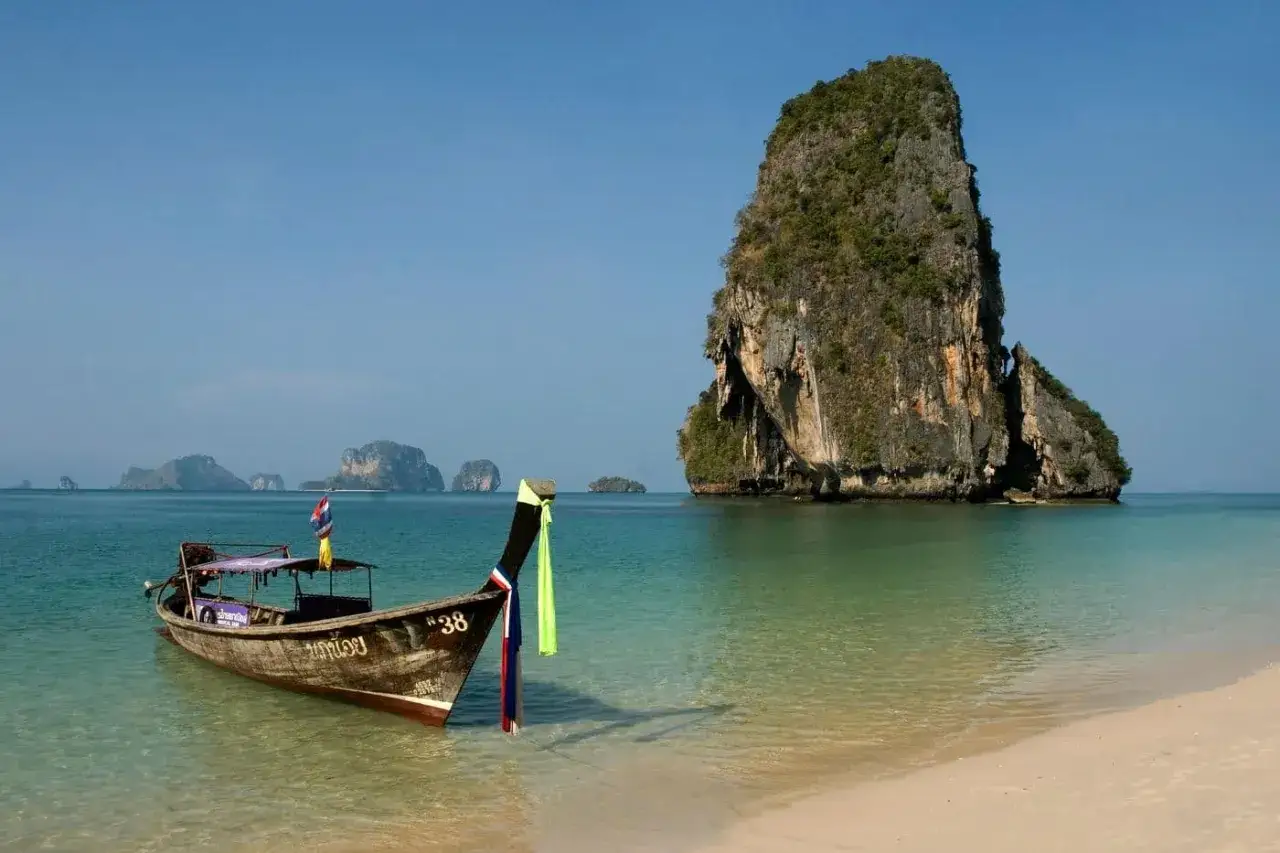 En traditionell longtailbåt vid en strand i Thailand. Kanske en bra tid att fundera på vaccin Thailand pris inför resan.