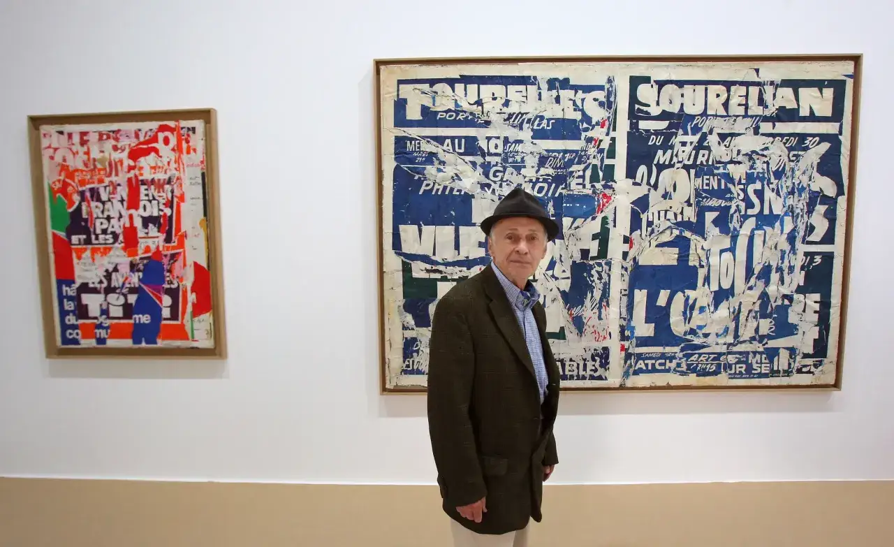 Jacques Villeglé, artiste des affiches lacérées, pose devant ses œuvres.