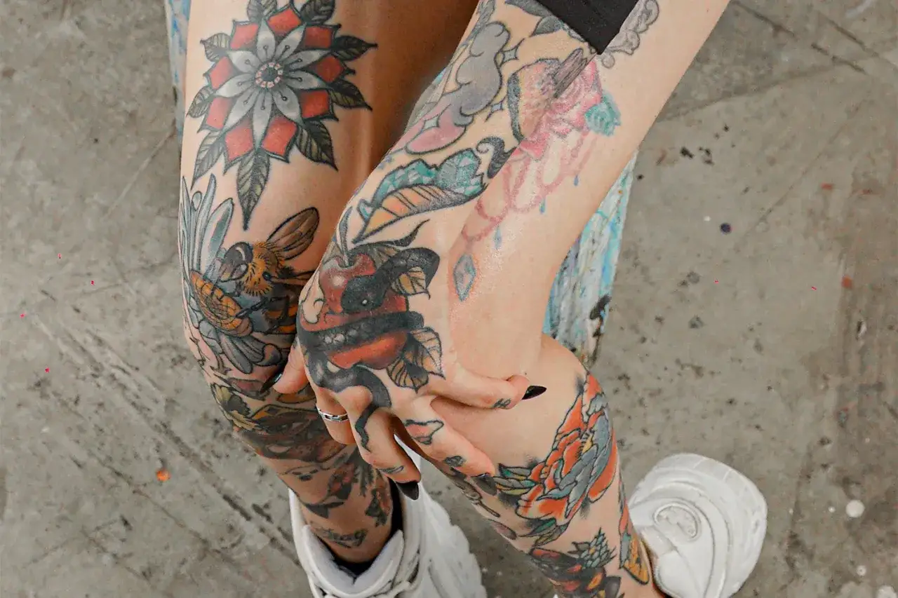 Bunte patchwork tattoo vorlagen zieren Arme und Beine: Blumen, Bienen, Schlangen und &Auml;pfel.