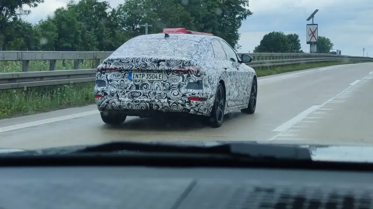 Tajemnicze, zamaskowane niemieckie auto jedzie po mokrej drodze.