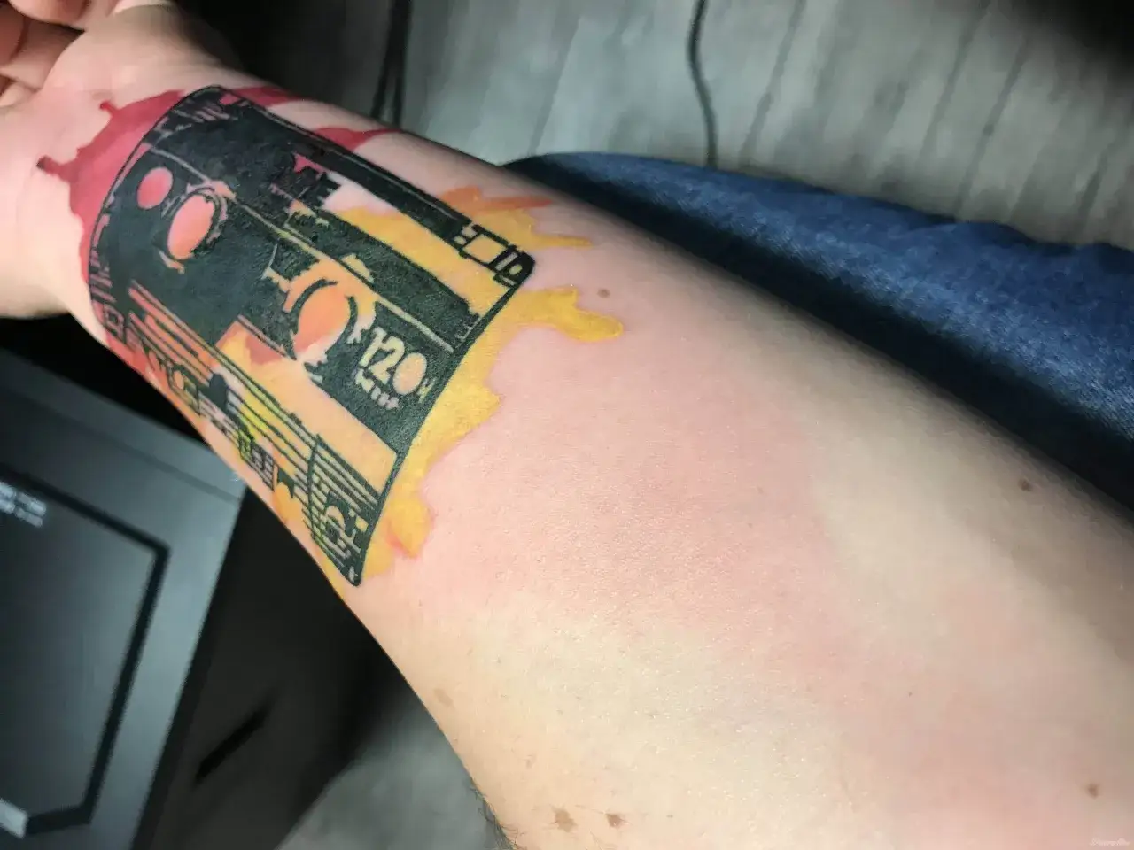 Opuchlizna po tatuazu w kształcie kasety magnetofonowej. Sk&oacute;ra wok&oacute;ł tatuażu jest lekko zaczerwieniona i spuchnięta, co jest normalnym objawem po zabiegu.