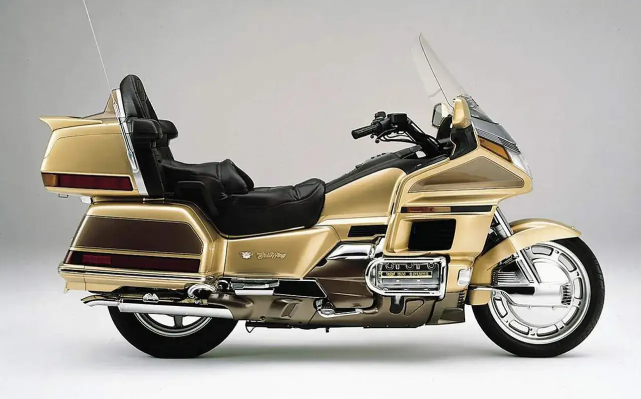Złoty Honda Goldwing 1500, klasyk turystyczny. Jego potężny silnik zapewnia płynną jazdę, a spalanie jest rozsądne jak na tę klasę.