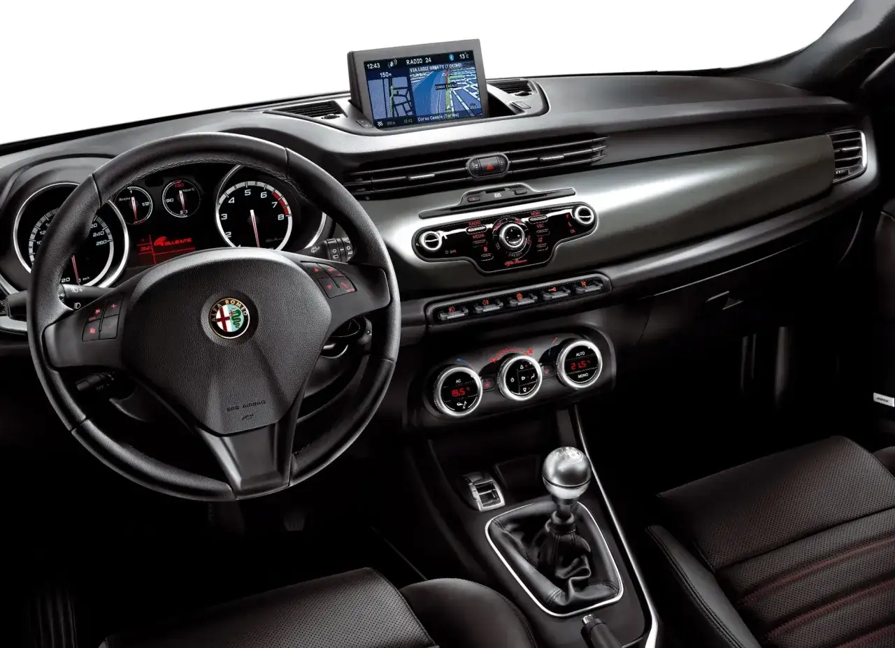 Wnętrze Alfa Romeo Giulietta, kierownica, nawigacja i panel sterowania. Wiele osób szuka alfa romeo giulietta opinie, by poznać ten samochód.