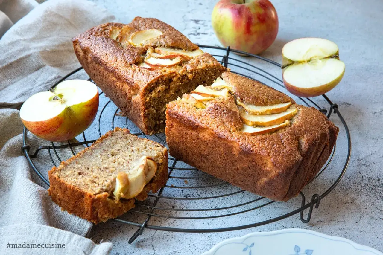 Saftiger Kuchen mit Apfelmus und frischen Apfelscheiben, auf einem Gitterrost abgek&uuml;hlt.