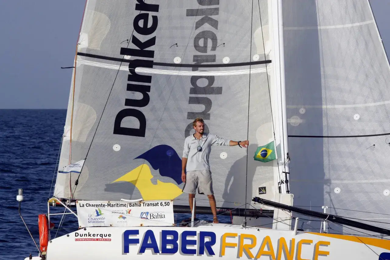 Thais le Cam, fier sur son voilier, brandit le drapeau brésilien. Le nom