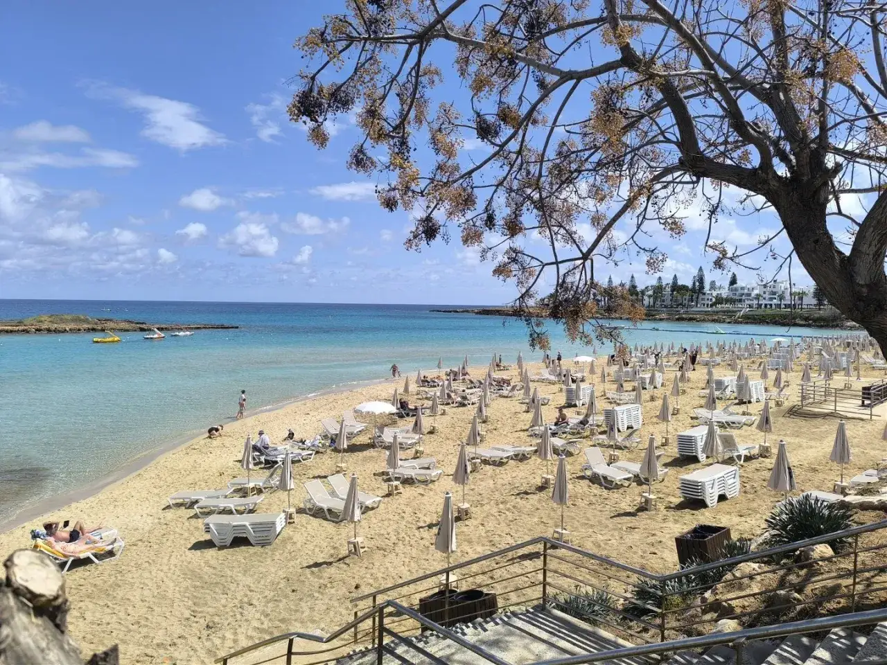 Piękna plaża z leżakami i parasolami, turkusowa woda i błękitne niebo. Czy to Pafos czy Larnaka?