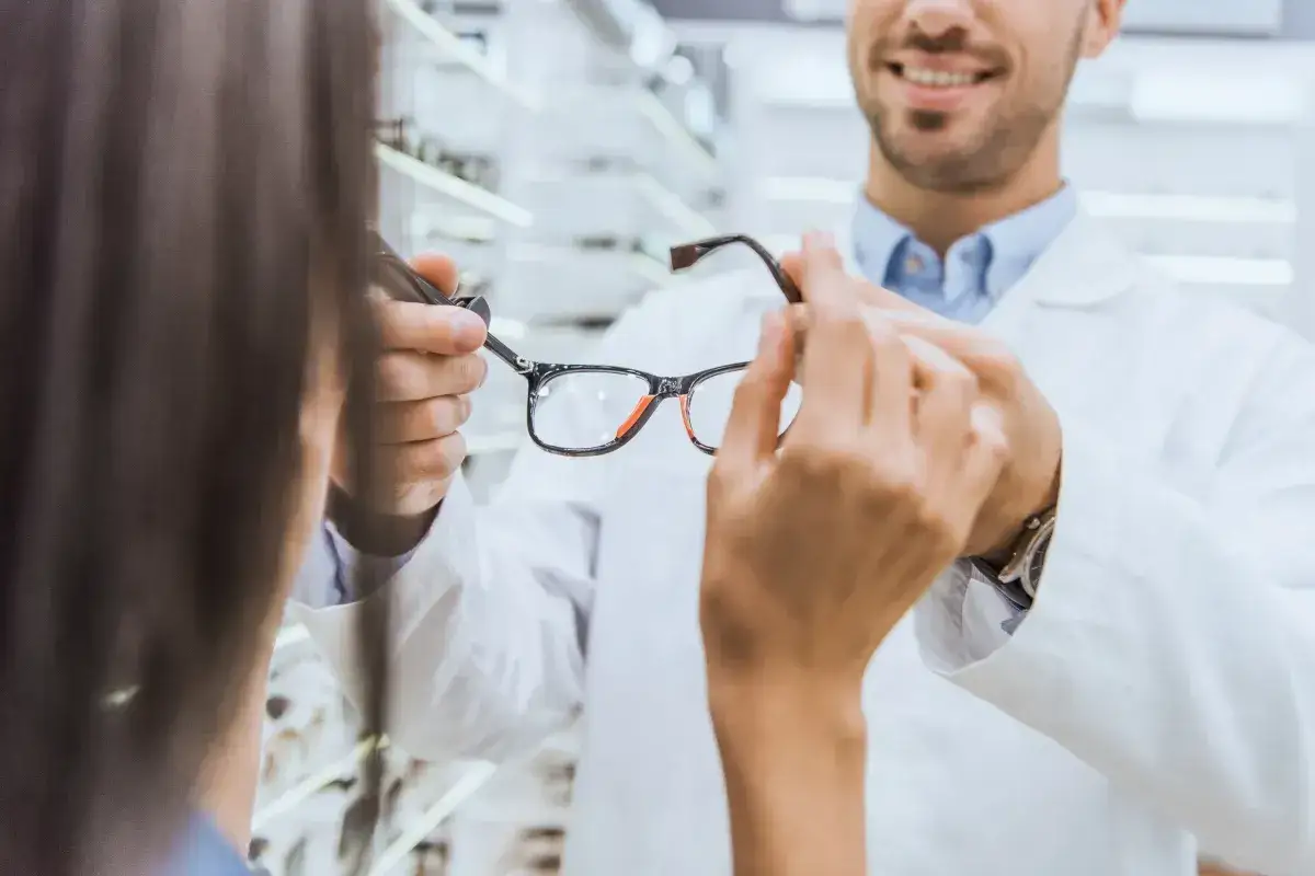 Okulista prezentuje okulary klientce, która może skorzystać z dofinansowania do okularów.