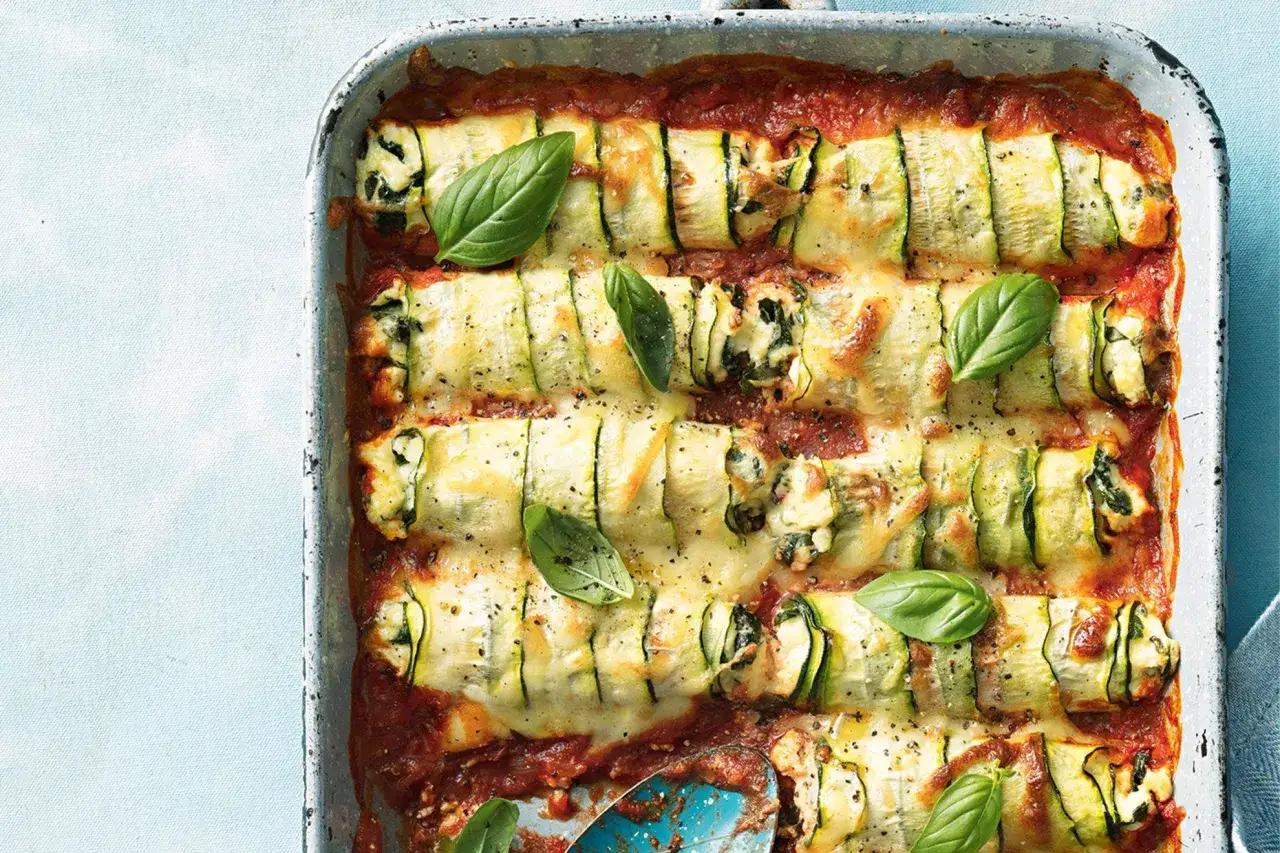 Zucchini-Cannelloni in Tomatensauce, &uuml;berbacken mit K&auml;se und garniert mit Basilikum.