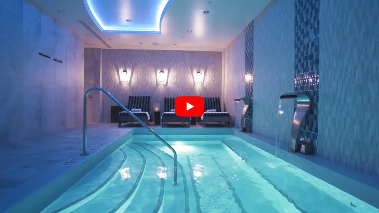Piscina interior con cascadas y tumbonas, un lugar perfecto para relajarse y ver qué se hace en un spa.