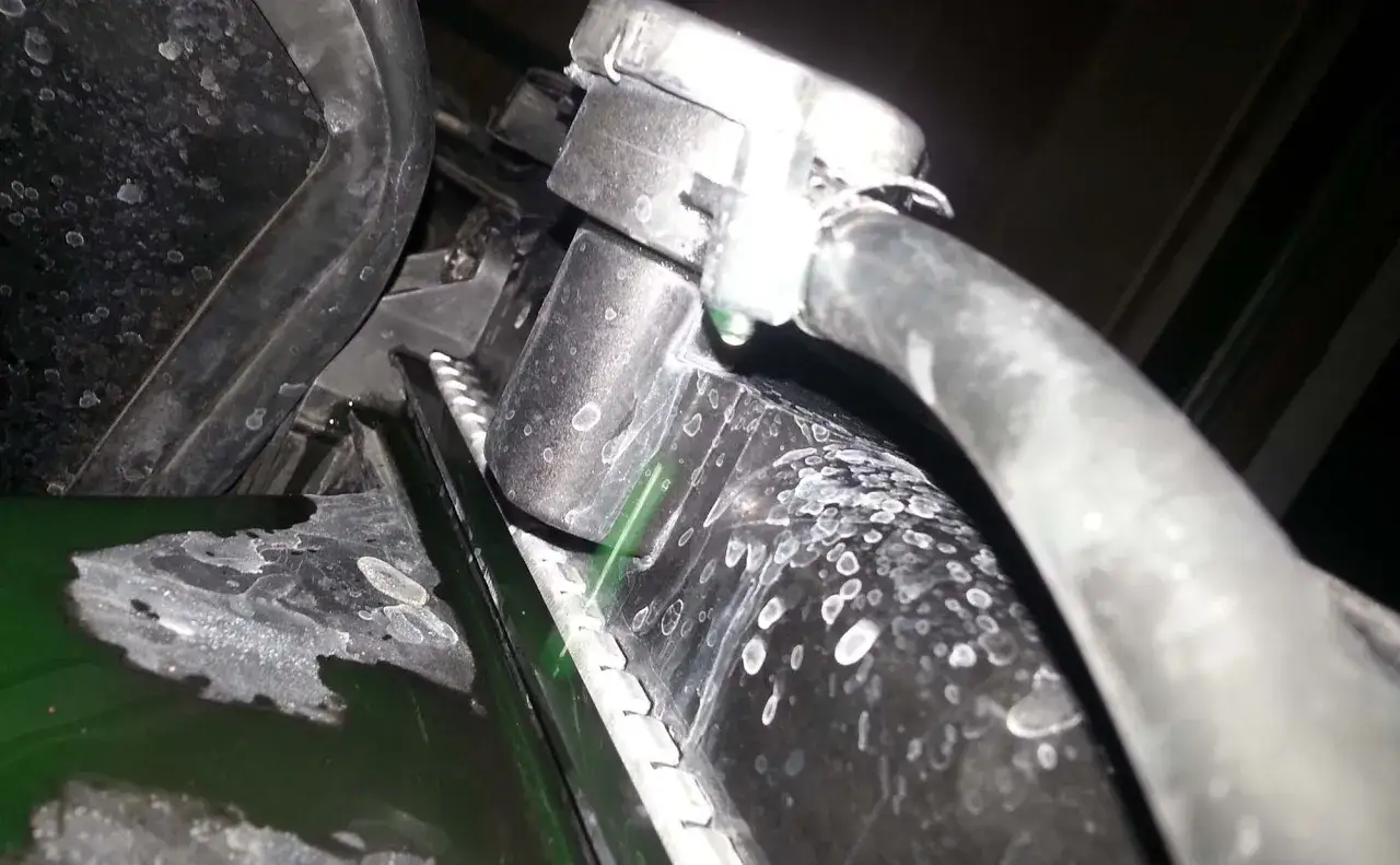 Green coolant drips from a leaking radiator hose. If your radiator is leaking, check hose clamps and for cracks.