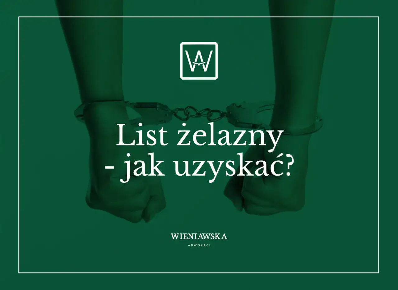 Z kajdankami na rękach i napisem