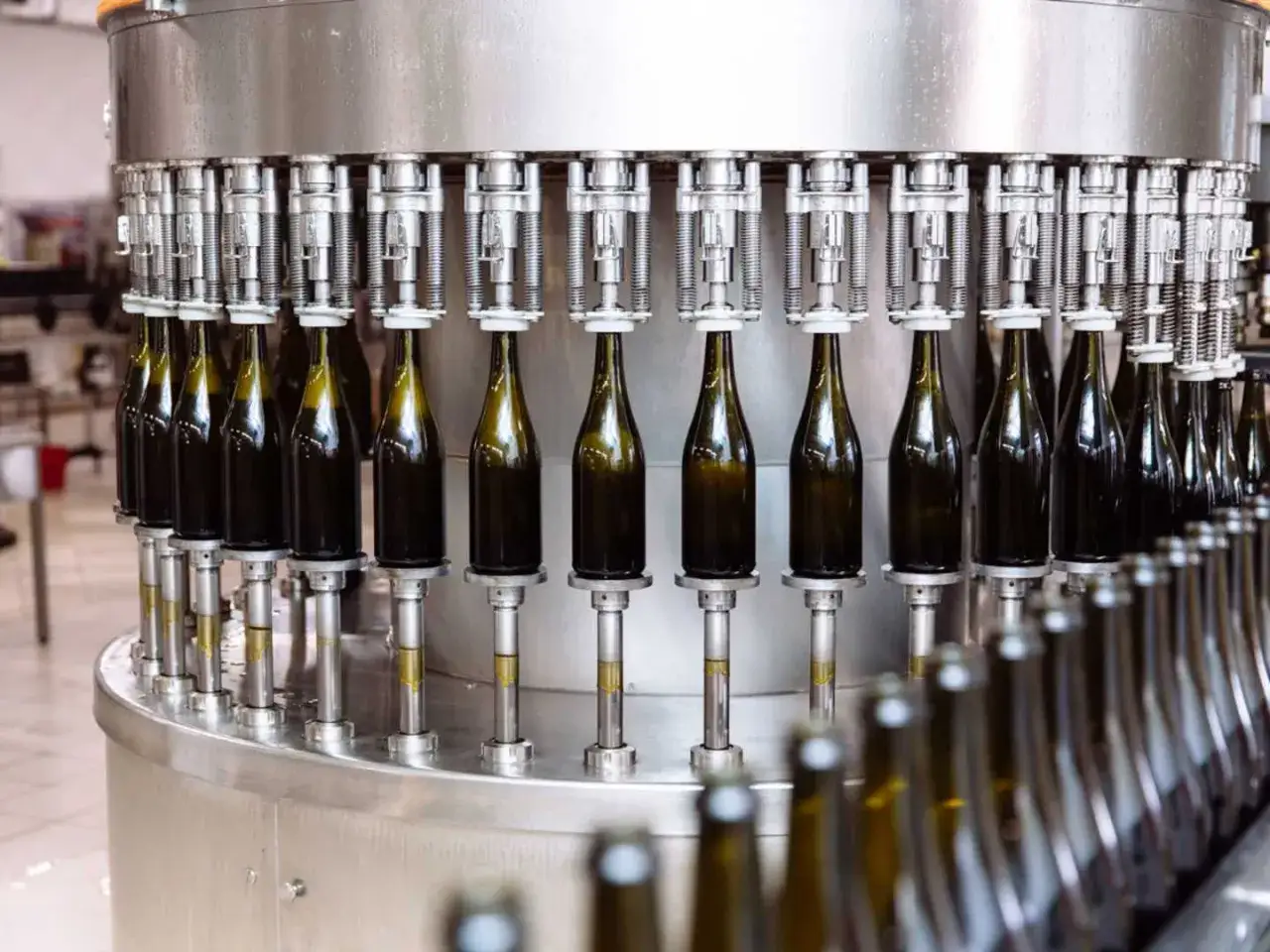 Vinflaskor fylls på en automatiserad linje. Processen kan innefatta tillsatser i vin för att förbättra smak eller hållbarhet.