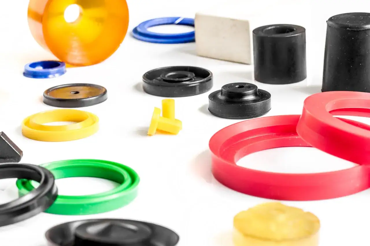 Vari componenti in gomma colorata, come guarnizioni e tappi, mostrano la versatilit&agrave; dell'elastomero, cos'&egrave; e le sue applicazioni.