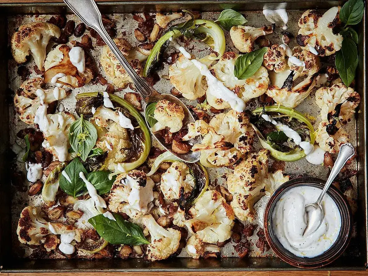 Rostad blomkål i ugn med en krämig sås, färska örter och nötter. En härlig och smakrik rätt.